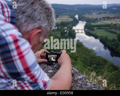 Ein Tourist nimmt ein Foto der Fluss Dordogne fließt durch die Périgord-Landschaft im Süden Frankreichs. Stockfoto