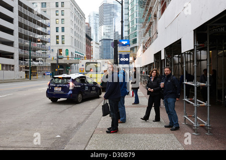 am frühen Morgen Pendler warten auf einen Bus an der Haltestelle außerhalb Waterfront Station in der Innenstadt von Vancouver BC Kanada Stockfoto