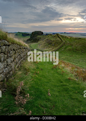 Der Roman Wall bei Sonnenaufgang mit Blick auf die aufgehende Sonne im Osten nahe Housesteads Roman Fort in Northumberland Stockfoto