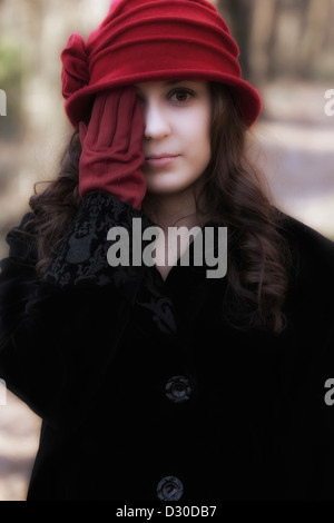 eine schöne junge Frau mit einem roten Hut und rote Handschuhe Stockfoto
