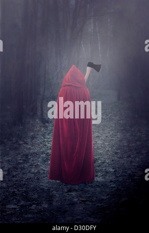 eine Frau in einem roten Mantel mit einer Axt Stockfoto
