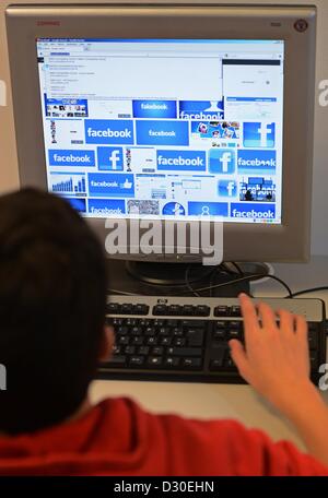 (ABBILDUNG) Eine Illustration zeigt ein Jüngling sitzt hinter einem Computer-Monitor zeigt Bilder von Facebook an der Berlin School Cosmoplitan bei einem Pressegespräch am Safer Internet Day in Berlin, Deutschland, 5. Februar 2013. Foto: Jens Kalaene Stockfoto