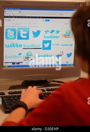 (ABBILDUNG) Eine Illustration zeigt ein Jüngling sitzt hinter einem Computer-Monitor zeigt Bilder von Twitter in der Berliner Cosmoplitan Schule bei einem Pressegespräch am Safer Internet Day in Berlin, Deutschland, 5. Februar 2013. Foto: Jens Kalaene Stockfoto