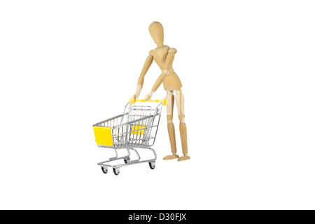 Eine weibliche Holzpuppe treibt einen Einkaufswagen Stockfoto