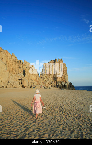Frau zu Fuß auf Sand und Granit Felsen an Land enden, Solmar Strand Cabo San Lucas, Baja California Sur, Mexiko Stockfoto