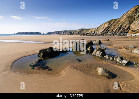 Menschenleerer, unberührter Strand bei Marloes in Pembrokeshire bei Ebbe mit einem klaren Felsenpool im Vordergrund an einem sonnigen Tag. Stockfoto