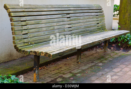 Stadt-Parkbank Perspektive gegen tan Mauerbau Stockfoto