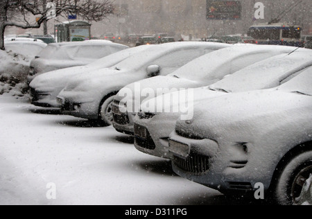 Autos sind unter Schnee während eines Schneefalls Stockfoto