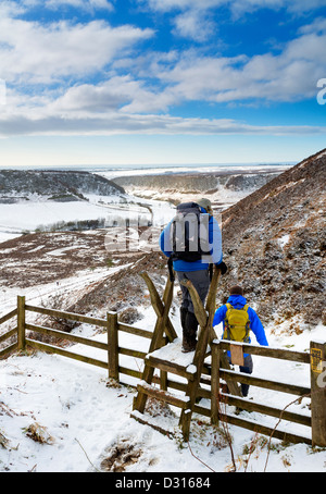 Ein paar Wanderer trotzen der Kälte den Weg zu niedrigen Horcum auf der North Yorkshire Moors zu nehmen Stockfoto