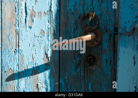 Eine alte bemalte Holztür mit Metallgriff und Krawatte Ring mit einer Schlaufe aus Draht angebracht, um Haken um zu halten, schließen. Stockfoto