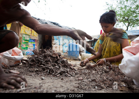 Armut leben in Tehkhand Slum, Delhi, Indien. Familie recycling Schrott auf den Straßen befinden sich kleine Lebensunterhalt zu verdienen. Stockfoto