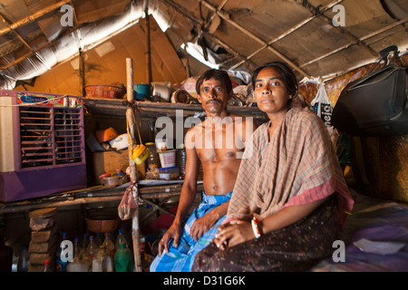 Armut leben in Tehkhand Slum, Delhi, Indien. Mann und Frau sitzen in ihrem Haus. Stockfoto