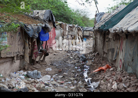 Armut leben in Tehkhand Slum, Delhi, Indien. Häuser auf s-Bahn mit schlechten hygienischen Verhältnissen und offener Abwasserkanal. Stockfoto