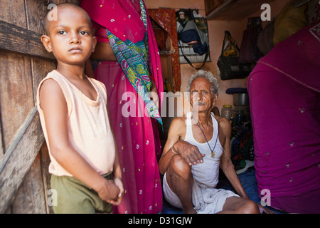 Junge indische Kind steht in der Tür ihres Hauses in Tehkhand Slum, Delhi, Indien.  8 Familienmitglieder leben hier. Stockfoto