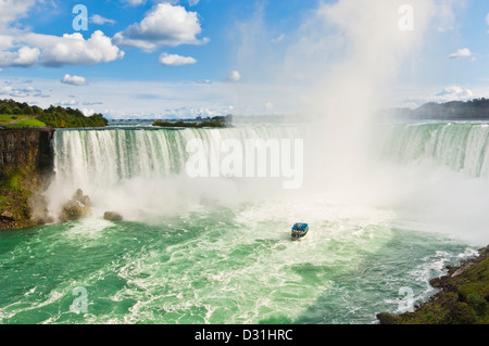 Magd des Bootes Nebel Kreuzfahrt mit Touristen in blauen Regenmäntel Horseshoe Falls auf der Niagara River Ontario Kanada Stockfoto