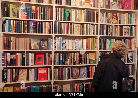 Eine Frau, die Durchsicht der Bücher in der Buchhandlung G. Heywood Hill Ltd, 10 Curzon Street, London, UK. Stockfoto