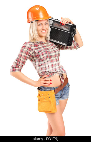 Lächelnd Arbeitnehmerin mit Helm Radiohören isoliert auf weißem Hintergrund Stockfoto