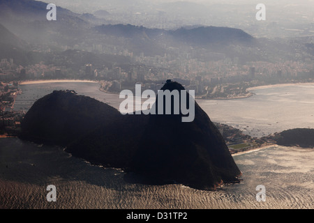 Silhouette aus Zuckerhut und Morro da Urca Gebirge und der Blick auf Rio de Janeiro Stadt an einem nebligen und heißen Sommermorgen - Botafogo Strand im Hintergrund links und Flamengo Park im Vordergrund rechts - nebiger und heißer Sommermorgen mit hoher Luftfeuchtigkeit In der Luft. Stockfoto