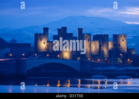 Conwy Castle in der Dämmerung / Nacht / Dämmerung mit Schnee am Berg hinter Conwy Grafschaft North Wales UK Stockfoto