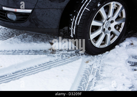 Auto mit Winter Reifen fährt auf einer Straße mit Schnee bedeckt. Stockfoto