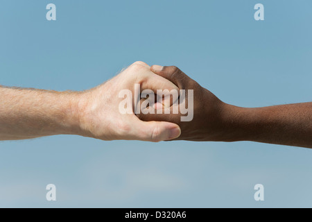 Indische und englische Hände. Westliche und Östliche Hand schütteln vor blauem Himmel. Indien. Eine Menschheit Konzept. Stockfoto