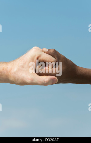 Indische und englische Hände. Westliche und Östliche Hand schütteln vor blauem Himmel. Indien. Eine Menschheit Konzept. Stockfoto