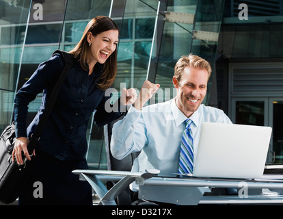 Kaukasische Geschäftsleute jubeln am laptop Stockfoto