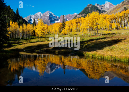 Gelbe Bäume und Berge spiegeln sich in stillem Wasser Stockfoto