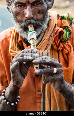 Indischen sadhu/Bettler spielen eine Flöte portrait. Andhra Pradesh, Indien Stockfoto