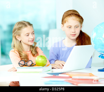 Porträt von smart Schülerinnen sitzen im Klassenzimmer vor laptop Stockfoto