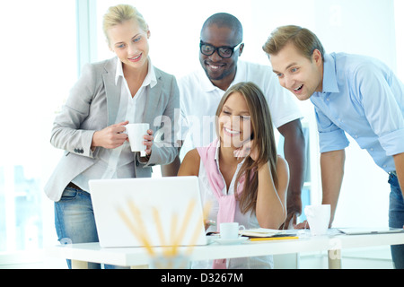 Gruppe von freundlichen Studenten oder Geschäftsleute versammelten sich vor laptop Stockfoto