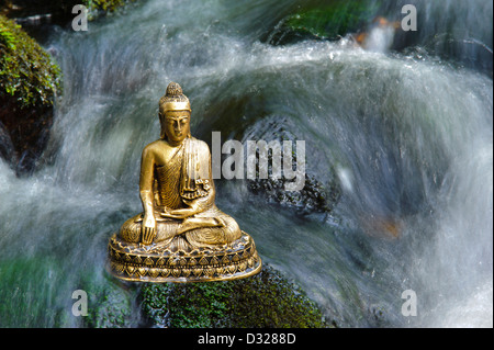 Buddhafigur sitzt im Wasserfall Stockfoto