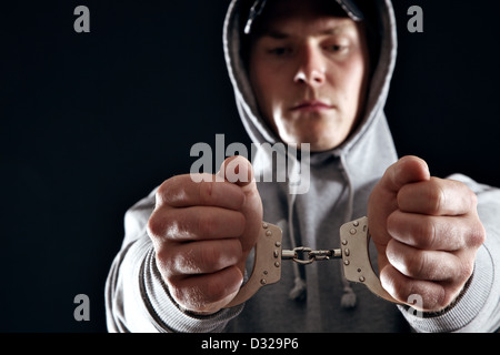 Gangster in Handschellen in schwarzem Hintergrund isoliert Stockfoto