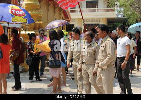 Lächelnde Offiziere bei der Einweihung der ein Novize in einem Tempel in Pranburi, Thailand an einem heißen Tag. Stockfoto