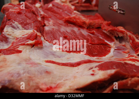 Platten von rotem und weißem Fleisch und Knochen mit Fett auf einem unordentlichen Metzger Tisch bereit, geschnitten und sortiert werden. Stockfoto