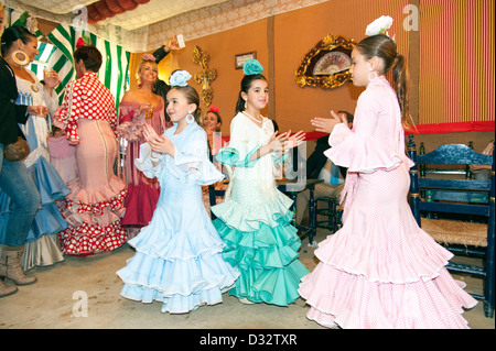 Junge Mädchen in bunten Flamenco-Kleider tanzen in einem Caseta an die Feria de Sevilla, Spanien Stockfoto