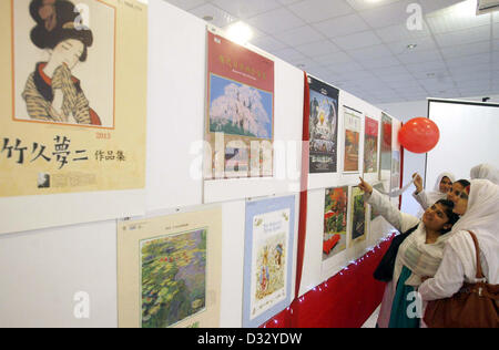 Besucher nehmen interessiert Kalender während japanische Kalender-Ausstellung im Gandhara Universität in Peshawar am Donnerstag, 7. Februar 2013 statt. Stockfoto