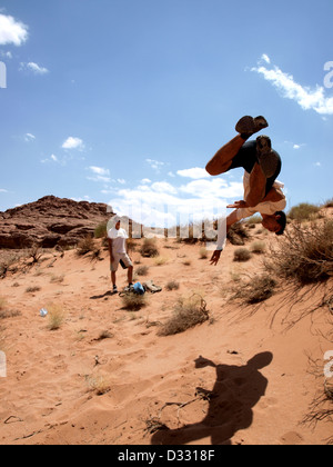 Mann springt in die Luft in der Wüste im Wadi Rum. Stockfoto