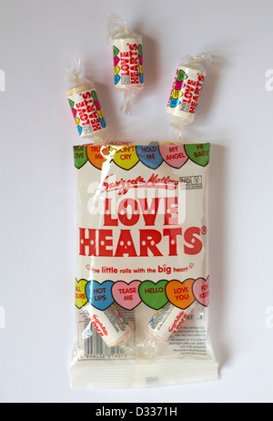 Tüte mit Swizzels Matlow Love Hearts Süßigkeiten Bonbons mit individuellen Packungen isoliert auf weißem Hintergrund - liebensüße von oben Stockfoto