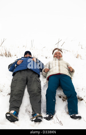 Mittleren Alter Brautpaar entspannend auf Schnee im Winterurlaub. Stockfoto