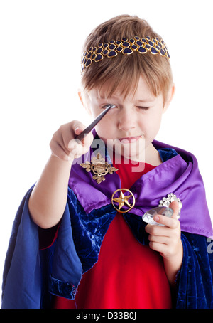 kleiner Junge gibt sich als Assistent König wirft Bann mit Zauberstab. Stockfoto