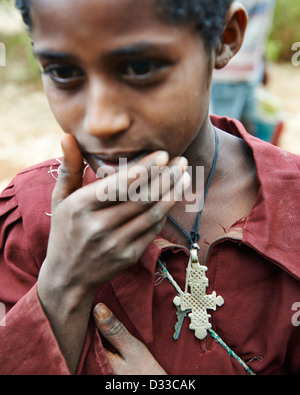 Ein kleiner Junge tragen eine koptische Kreuz um seinen Hals Posen Stockfoto