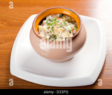 Gebratene Kartoffelscheiben in rustikalen Tontopf Stockfoto