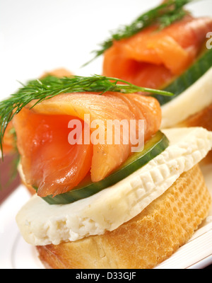 Kanapees mit geräuchertem Lachs, Käse und Gurken. Nahaufnahme Stockfoto