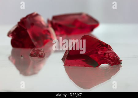 Rote Jelly Blobs auf einer reflektierenden Glasoberfläche / Landschaft Stockfoto