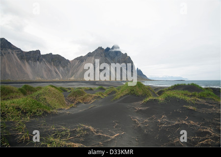 Isländische Berge und Felsen von der Küste entfernt an der Südküste Stockfoto