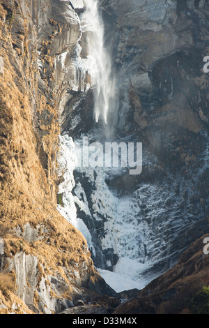 Ein teilweise gefrorenen Wasserfall an den unteren Hängen des Machapuchare oder der Heiligen, Fish Tail Peak im Annapurna Himalaya, Nepal. Stockfoto