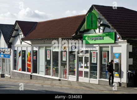 Mann mit ATM vor Co-Operative Geschäft in Bowness, Nationalpark Lake District, Cumbria, England UK Stockfoto