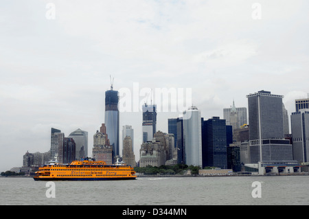 Staten Island Ferry Abfahrt von Manhattan auf seiner Reise nach Staten Island, fotografiert mit den Wolkenkratzern der Stadt hinter sich, NYC. USA Stockfoto