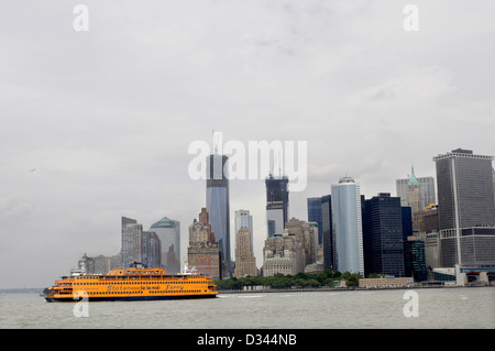 Staten Island Ferry Abfahrt von Manhattan auf seiner Reise nach Staten Island, fotografiert mit den Wolkenkratzern der Stadt hinter sich, NYC. USA Stockfoto